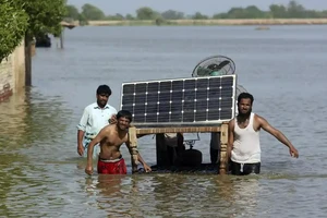 Người dân mang đồ đạc ra khỏi căn nhà bị ngập lụt của họ ở huyện Jaffarabad, tỉnh Baluchistan (Pakistan). Ảnh: AP