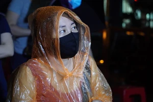 Người dân đội mưa đi lấy mẫu xét nghiệm COVID-19 trong đêm