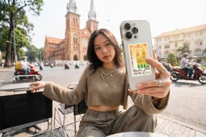Một bạn trẻ (Gen Z) ăn mặc năng động, tay cầm chiếc điện thoại có ốp lưng trong suốt. Phía sau ốp lưng lấp ló chiếc Thẻ vàng Travel Card 0.1 chỉ rực rỡ màu sắc.