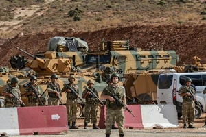 Binh sĩ Thổ Nhĩ Kỳ đứng bên xe bọc thép gần biên giới Syria-Thổ Nhĩ Kỳ.