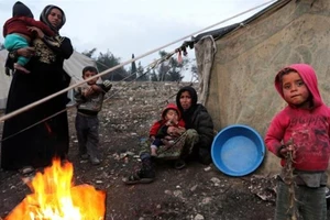 Người tị nạn Syria chạy khỏi Idlib vây quanh một đám lửa ở Afrin, Syria.