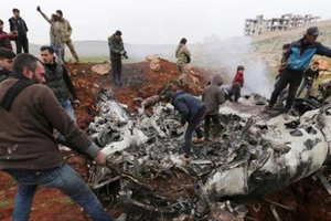 Người dân tập trung quanh mảnh vỡ chiếc trực thăng của chính phủ Syria bị bắn rơi ở tây Aleppo, Syria. Ảnh: AP