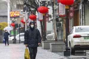 Một người đàn ông đi qua con đường vắng vẻ ở Vũ Hán, Hồ Bắc, Trung Quốc. 