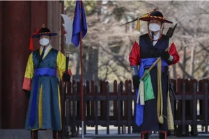 Nhân viên trong trang phục truyền thống đeo khẩu trang tại một cung điện ở Seoul, Hàn Quốc. 