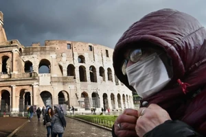 Du khách đeo khẩu trang tại Đấu trường La Mã ở Rome (Ý).Ảnh: SCMP