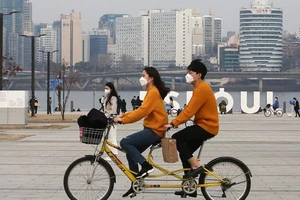Một cặp đôi đeo khẩu trang lái xe đạp đôi quanh một công viên ở Seoul, Hàn Quốc. Ảnh: AP