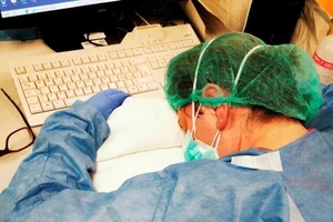 Một y tá nghỉ ngơi trong ca trực đêm ở bệnh viện Cremona của Ý. Ảnh: REUTERS