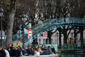 Người dân tập trung tại các bờ kênh đào Saint-Martin ở Paris (Pháp) hôm 25-3 khi các nhà hàng, tiệm cà phê đóng cửa do dịch COVID-19. Ảnh: AFP