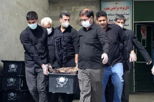 Một cỗ quan tài của bệnh nhân COVID-19 được khiêng đi tại nghĩa trang Beheshte Masoumeh ở TP Qom (Iran).