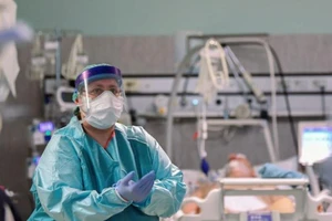 Một nhân viên y tế và một bệnh nhân mắc COVID-19 tại bệnh viện Oglio Po ở Cremona (Ý). Ảnh: REUTERS