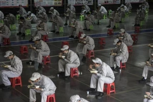 ông nhân tại nhà máy Dongfeng Fengshen ở Vũ Hán, tỉnh Hồ Bắc,Trung Quốc ăn trưa và giữ khoảng cách 2m.