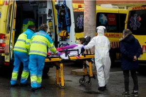 Nhân viên y tế đưa một bênh nhân lên xe cứu thương ở bệnh viện ĐH 12 de Octubre tại Madrid, Tây Ban Nha. Ảnh: REUTERS