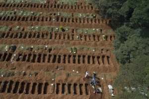Các nhân viên nghĩa trang tiến hành chôn cất một thi thể tại nghĩa trang Vila Formosa ở Sao Paulo, (Brazil). Ảnh: AP