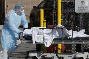 Một nhân viên y tế đưa thi thể một người tử vong vì COVID-19 tới nhà xác tạm thời bên ngoài Trung tâm y tế Wyckoff Heights ở New York, Mỹ. Ảnh: REUTERS