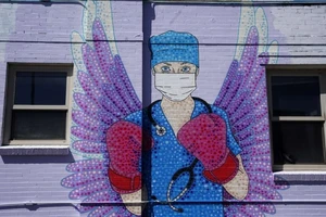 Một bức tranh được vẽ trên tường mô tả một nhân viên y tế ở TP Denver, bang Colorado của Mỹ. Ảnh: AFP