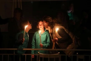 Một gia đình thắp nến ngoài ban công trong lễ Phục sinh ở Athens, Hy Lạp ngày 19-4. Ảnh: REUTERS