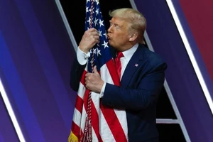 Tổng thống Donald Trump hôn cờ Mỹ. Ảnh: AP