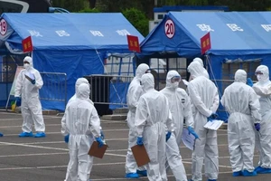 Các nhân viên chính phủ Trung Quốc điều phối đưa khách du lịch đến từ Vũ Hán tới các địa điểm cách ly tại Bắc Kinh. Ảnh: AP