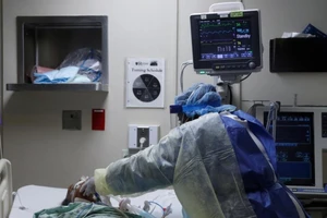 Y tá chăm sóc một bệnh nhân COVID-19 tại phòng chăm sóc tích cực ở Chicago, bang Illinois (Mỹ). Ảnh: REUTERS