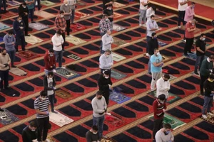 Người dân đeo khẩu trang và thực hiện giãn cách xã hội khi cầu nguyện tại Lebanon. Ảnh: REUTERS