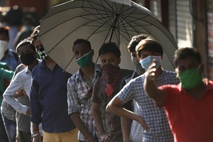 Người di cư chờ được đưa tới một trạm xe lửa trong thời gian phong tỏa kéo dài ở Mumbai, Ấn Độ. Ảnh: REUTERS