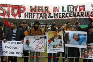 Người biểu tình cầm băng rôn ghi “Chấm dứt chiến tranh ở Libya, Haftar và lính đánh thuê”. Ảnh: AFP