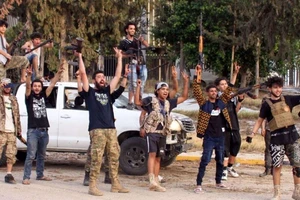 Các tay súng ủng hộ GNA vui mừng sau khi chiếm sân bay quốc tế Tripoli trừ LNA. Ảnh: AFP