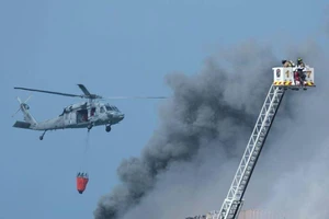 Trực thăng Hải quân Mỹ và lính cứu hỏa San Diego tiếp tục dập lửa trên tàu tấn công đổ bộ USS Bonhomme Richard. Ảnh: REUTERS/Mike Blake