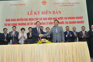 Chủ tịch Ủy ban Quản lý vốn Nhà nước tại DN Nguyễn Hoàng Anh (trái) và Bộ trưởng Công Thương Trần Tuấn Anh (phải) ký biên bản bàn giao các DN.