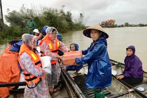 Đại diện Báo Pháp Luật TP.HCM trao quà, chia sẻ khó khăn với người dân vùng lũ.