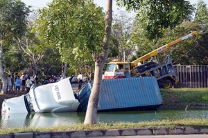 Container mất lái, lao xuống ao