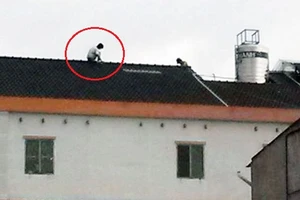 Tên trộm cố thủ 2 giờ trên mái nhà cao tầng