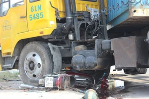 Xe máy nằm dưới gầm container một người nguy kịch