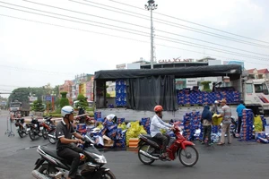 Xe tải chở bia bung thùng, người dân gom giúp tài xế