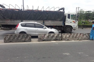 Xe tải ép ô tô vào dải phân cách ở Bình Tân