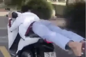 Vừa nằm vừa lái xe máy, thanh niên bị phạt 4 triệu đồng