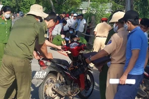 Chiếc xe máy được lực lượng chức năng đưa lên bờ. Ảnh: D.LỢI