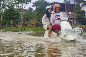 Mưa lớn dồn dập, lũ dâng cao, người dân Huế vội vã đưa xe đi tránh lũ