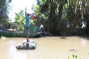 Lão nông chế bè qua sông bằng vỏ chai thuốc bảo vệ thực vật