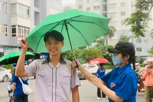 Thí sinh hớt hải 'chạy mưa' đến trường dự thi môn cuối cùng