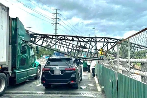 Cần cẩu công trình ngã đè trúng hai ô tô trên cầu vượt Mỹ Thủy