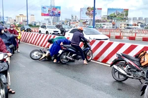 Nhiều người đi xe máy trượt té trên cầu Sài Gòn 