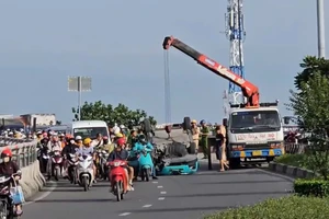 Xe taxi công nghệ bị lật trên cầu vượt Quang Trung