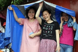 Phụ huynh đội mưa chờ con ngoài phòng thi