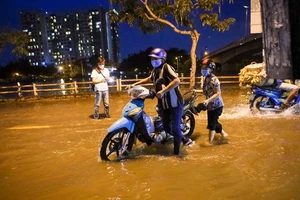 Ảnh: Dân khổ sở lội nước về nhà khi triều cường dâng