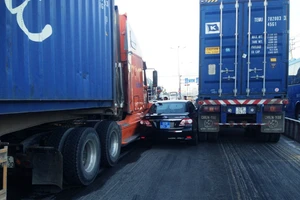 Hai container chèn ô tô, tài xế mắc kẹt