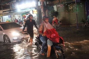 Mưa không kịp vuốt mặt, người dân bì bõm vượt ngập 