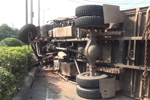 Xe tải chở gạch lật ngang, tài xế phụ xe mắc kẹt