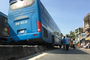 Xe khách vắt vẻo trên dải phân cách ở quận 12