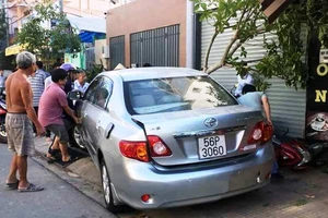 1 phụ nữ lùi ô tô từ nhà ra đường cuốn 4 xe máy vào gầm 